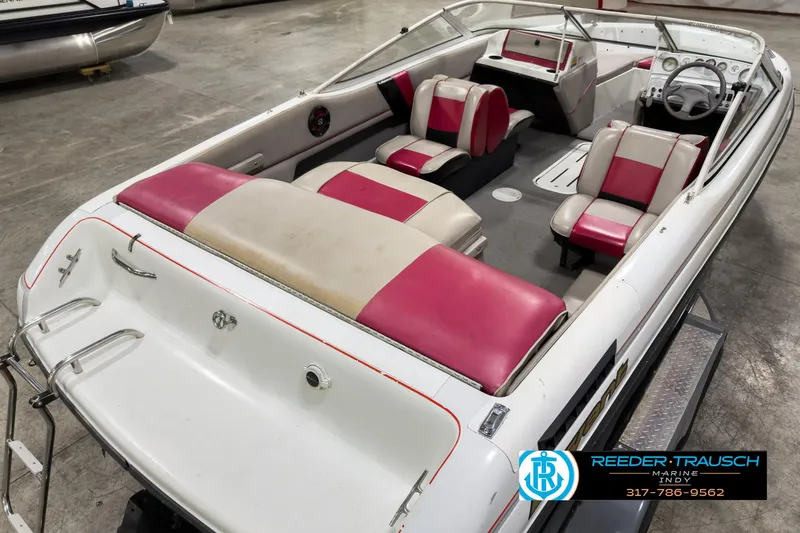 Slide: The Image of 1993 Bryant 200 boat with red and white interior, displayed in a showroom. - 9