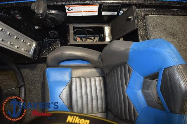 Slide: The Image of 2023 Blazer 625 Pro Elite boat interior with blue and black seats, open storage compartment. - 24