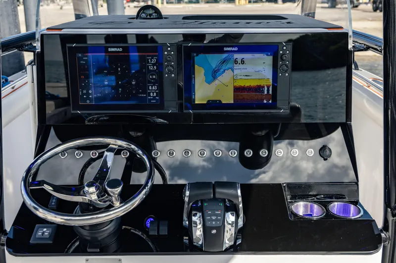 Slide: The Image of Marlago 35 boat dashboard with dual Simrad displays, steering wheel, and controls, 2005 model. - 11