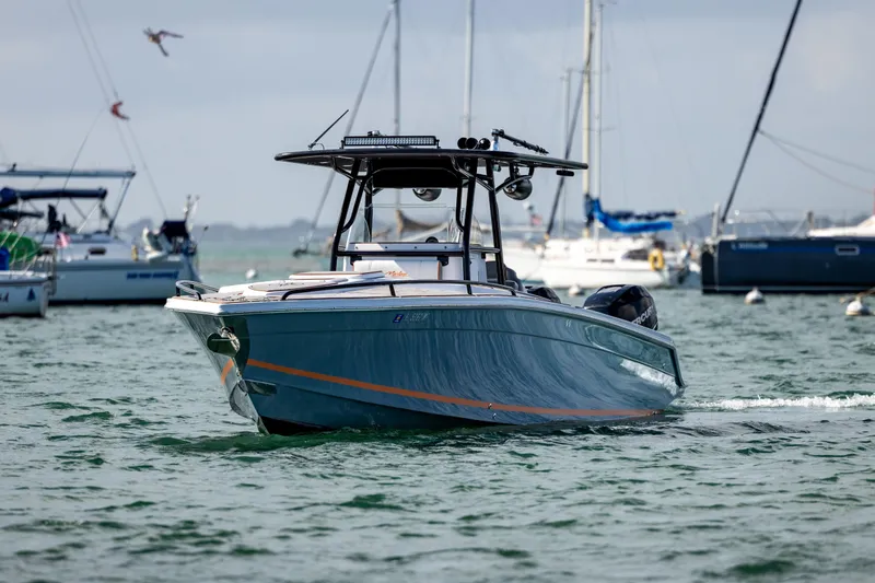 Slide: The Image of 2005 Marlago 35 boat cruising in a marina with sailboats in the background. - 2