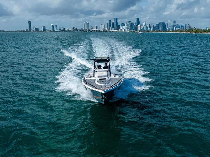 Slide: The Image of Marlago 35 boat cruising on ocean with city skyline in background, 2005 model. - 3