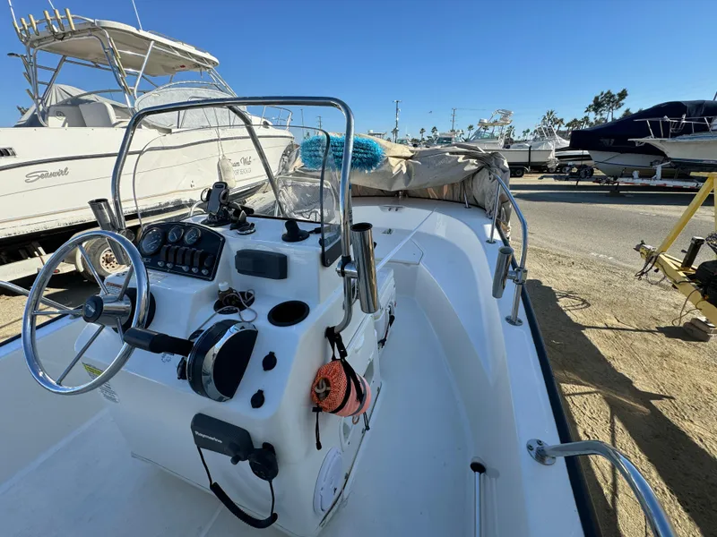 Slide: The Image of 2016 Boston Whaler 170 MONTUCK boat with steering console, docked under clear blue sky. - 15