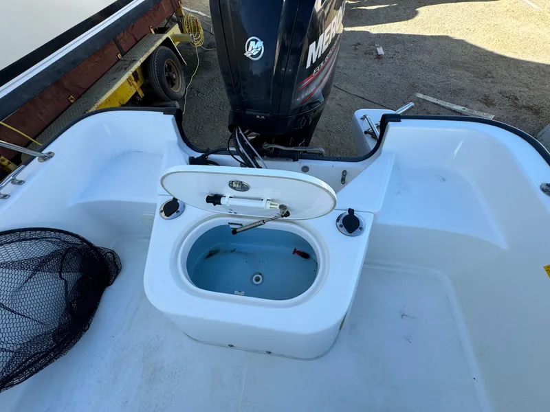 Slide: The Image of 2016 Boston Whaler 170 MONTUCK boat with open storage compartment and Mercury outboard motor. - 21