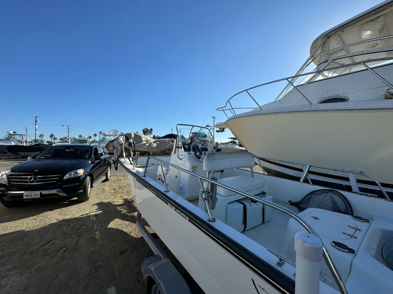 Slide: The Image of 2016 Boston Whaler 170 MONTUCK boat parked beside a car in a marina. - 3