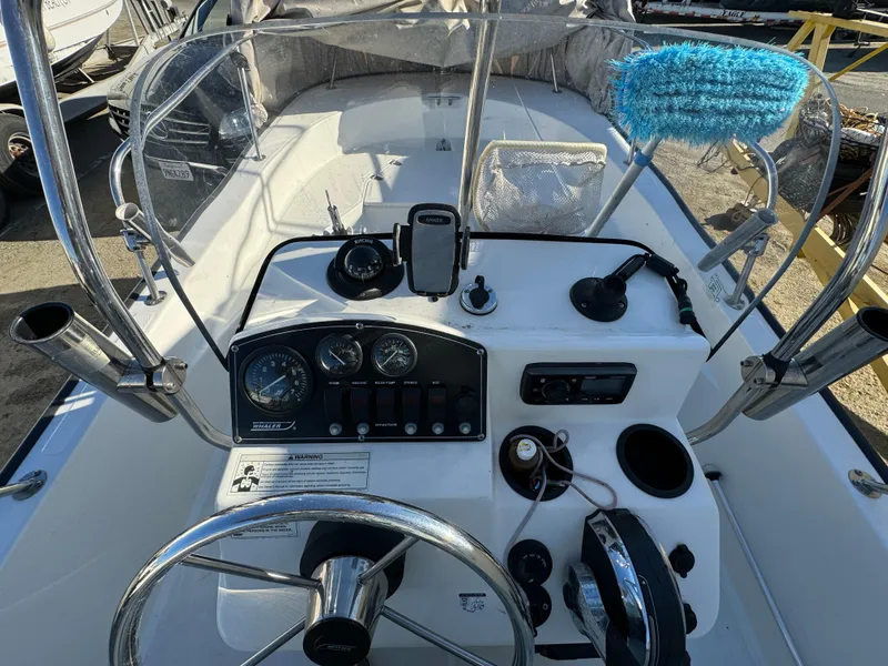 Slide: The Image of 2016 Boston Whaler 170 MONTUCK boat dashboard with steering wheel and controls. - 30
