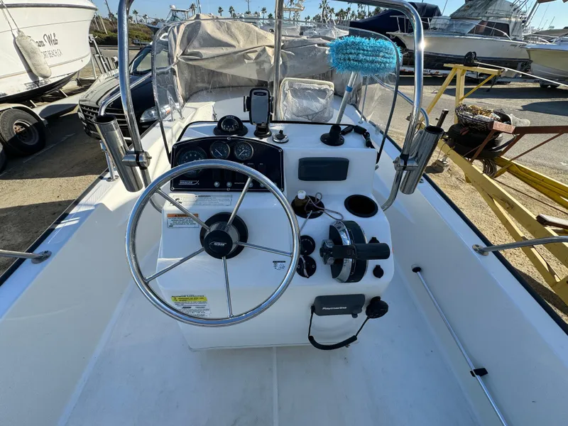 Slide: The Image of 2016 Boston Whaler 170 MONTUCK boat dashboard with steering wheel and controls. - 39