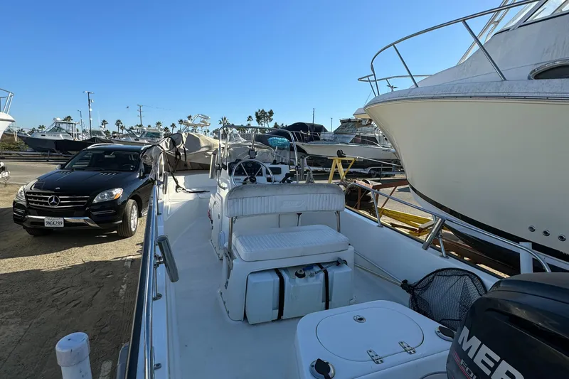 Slide: The Image of 2016 Boston Whaler 170 MONTUCK boat docked near parked vehicles in a marina. - 41