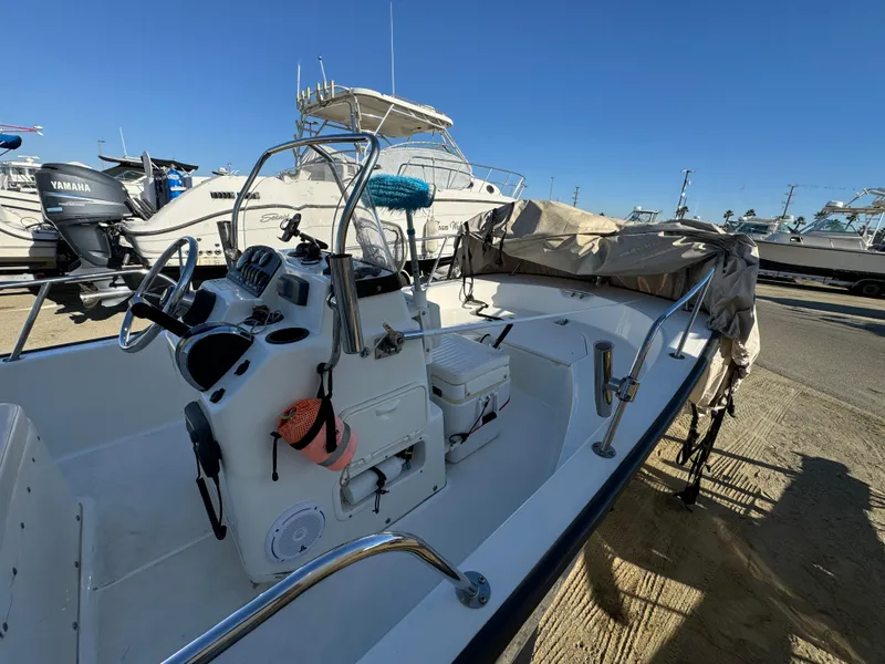Slide: The Image of 2016 Boston Whaler 170 MONTUCK boat with covered seating, docked under clear blue sky. - 7