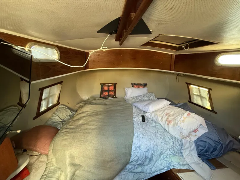 Slide: The Image of Cozy cabin interior of a 1973 Islander 40 sailboat with a neatly made bed. - 15