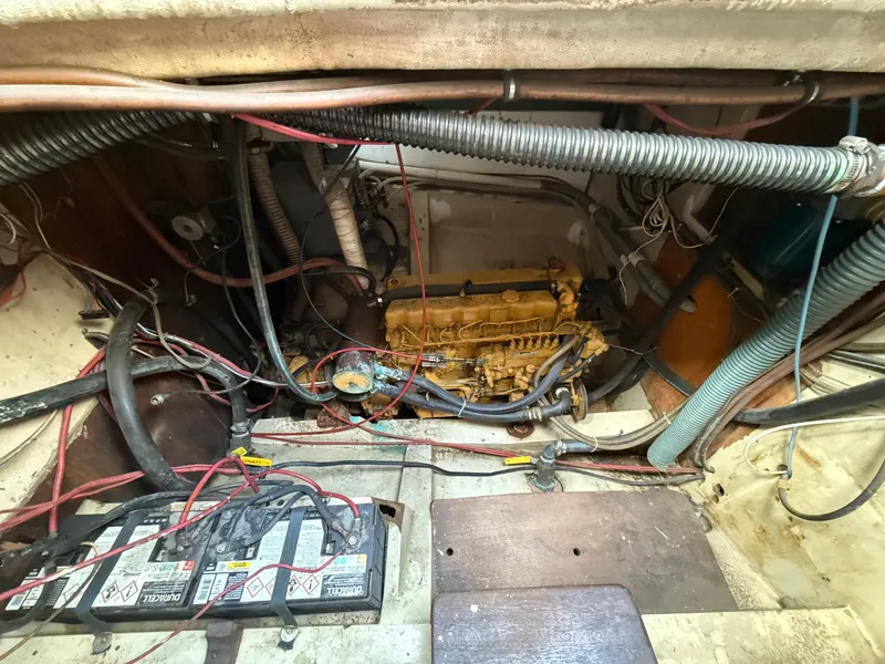 Slide: The Image of Engine compartment of a 1973 Islander 40 sailboat, showing wiring and batteries. - 19