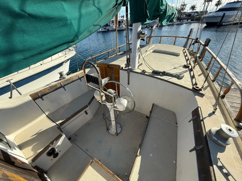 Slide: The Image of 1973 Islander 40 sailboat cockpit with green canopy, docked in a marina. - 4
