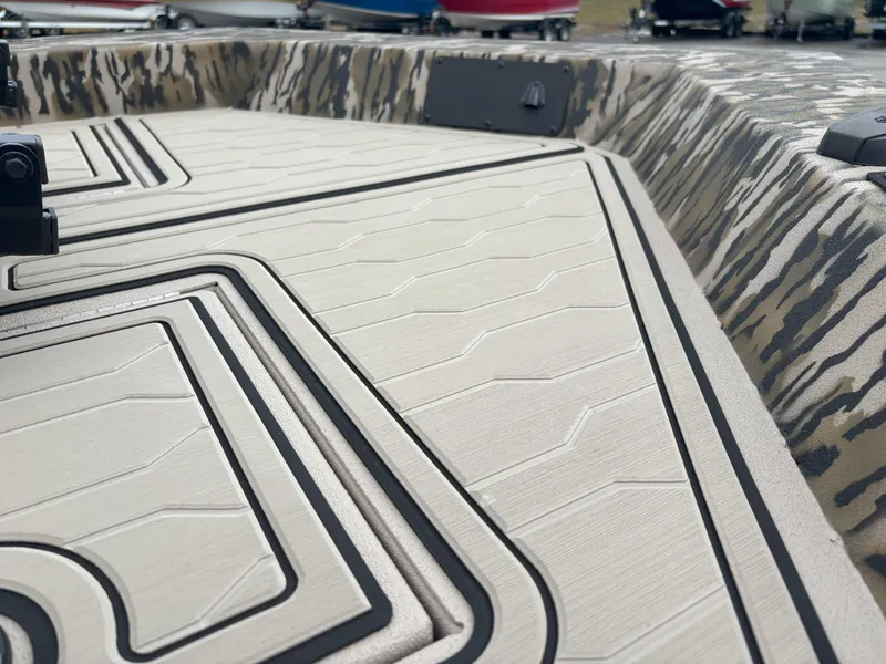 Slide: The Image of 2025 Avid 18 Commander boat deck with camouflage pattern and textured flooring. - 11