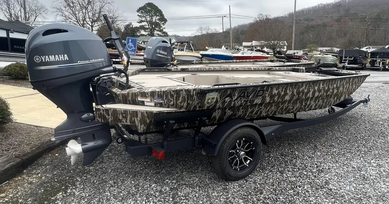 Slide: The Image of 2025 Avid 18 Commander boat with Yamaha engine, camo design, on a trailer. - 15
