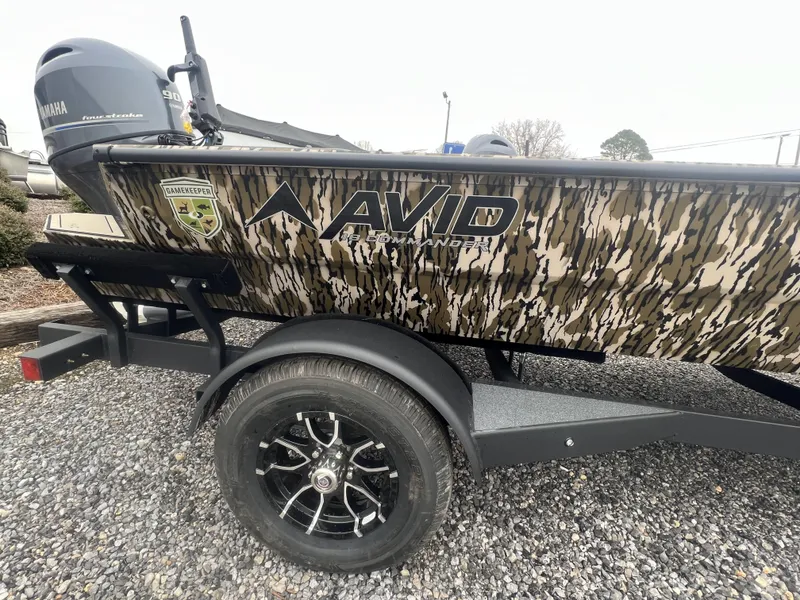 Slide: The Image of 2025 Avid 18 Commander boat with camouflage design and Yamaha motor on trailer. - 2