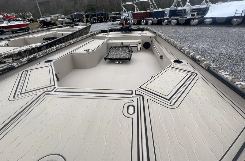 Slide: The Image of 2025 Avid 18 Commander boat deck with storage compartments, parked among other boats. - 3