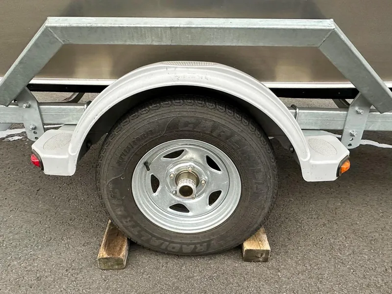 Slide: The Image of 2017 Hewescraft 160 Sportsman trailer wheel on wooden block, close-up view. - 22