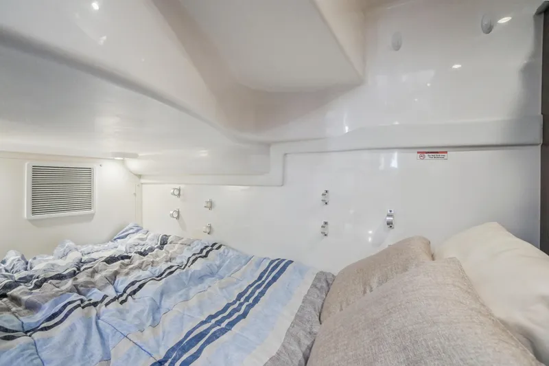 Slide: The Image of 2023 Pursuit OS 355 Offshore cabin interior with cozy bedding and modern design. - 13