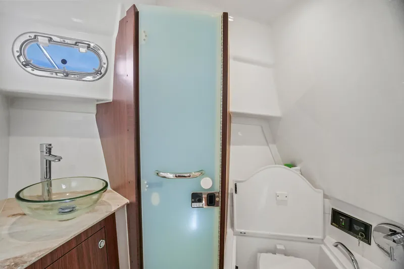 Slide: The Image of 2023 Pursuit OS 355 Offshore boat bathroom with modern sink and frosted glass door. - 14