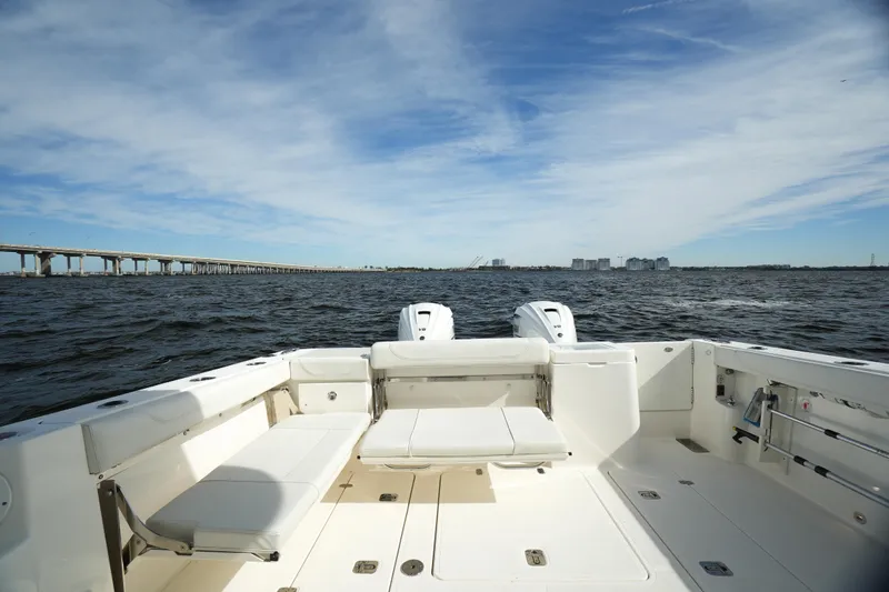 Slide: The Image of 2023 Pursuit OS 355 Offshore boat on open water with bridge in background. - 21