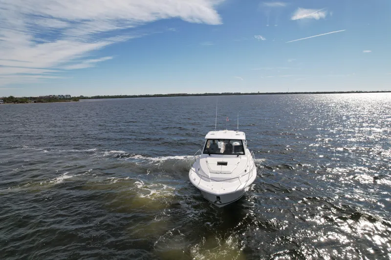 Slide: The Image of 2023 Pursuit OS 355 Offshore boat cruising on open water under a clear sky. - 3