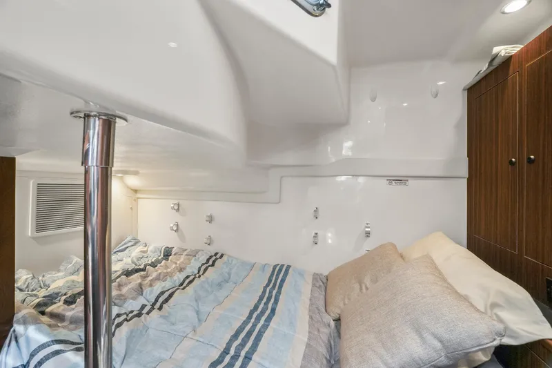 Slide: The Image of 2023 Pursuit OS 355 Offshore cabin interior with bed and storage. - 30