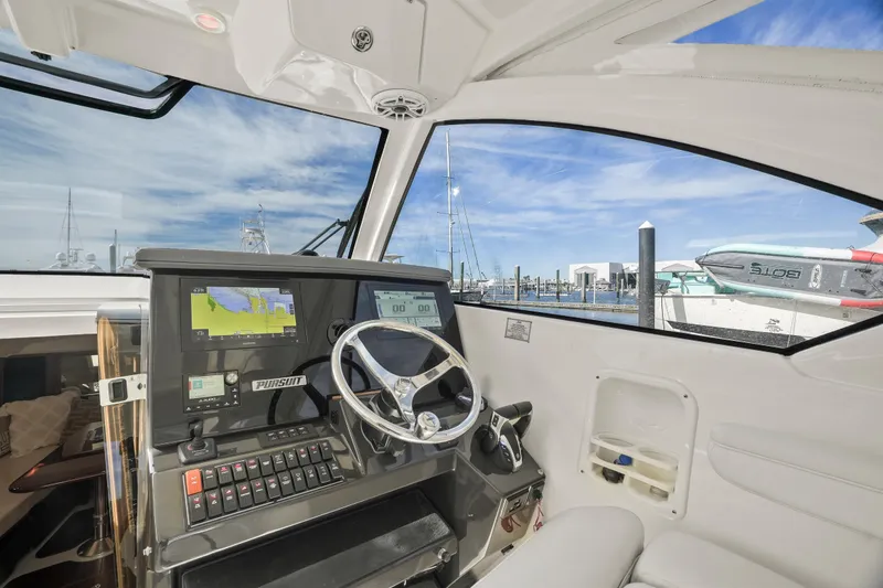 Slide: The Image of 2023 Pursuit OS 355 Offshore boat cockpit with navigation system and steering wheel. - 34