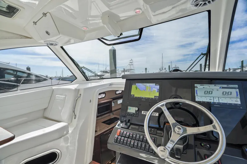 Slide: The Image of 2023 Pursuit OS 355 Offshore boat cockpit with modern navigation system and steering wheel. - 37