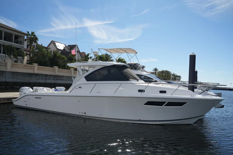Slide: The Image of 2023 Pursuit OS 355 Offshore boat docked in a marina under clear skies. - 8