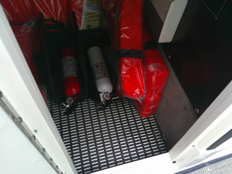 Slide: The Image of Safety equipment storage on 2020 Monterey 305 Super Sport boat, featuring fire extinguishers and life jackets. - 30