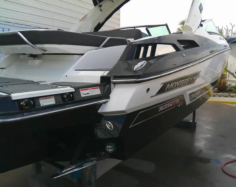 Slide: The Image of 2020 Monterey 305 Super Sport boat, sleek design, black and white exterior, docked. - 32