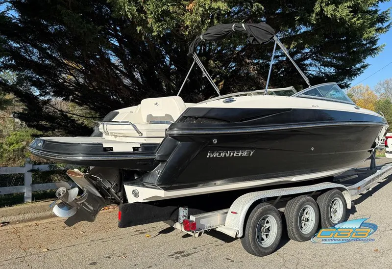 Slide: The Image of 2013 Monterey 264FS boat on trailer, black and white exterior, parked outdoors. - 4