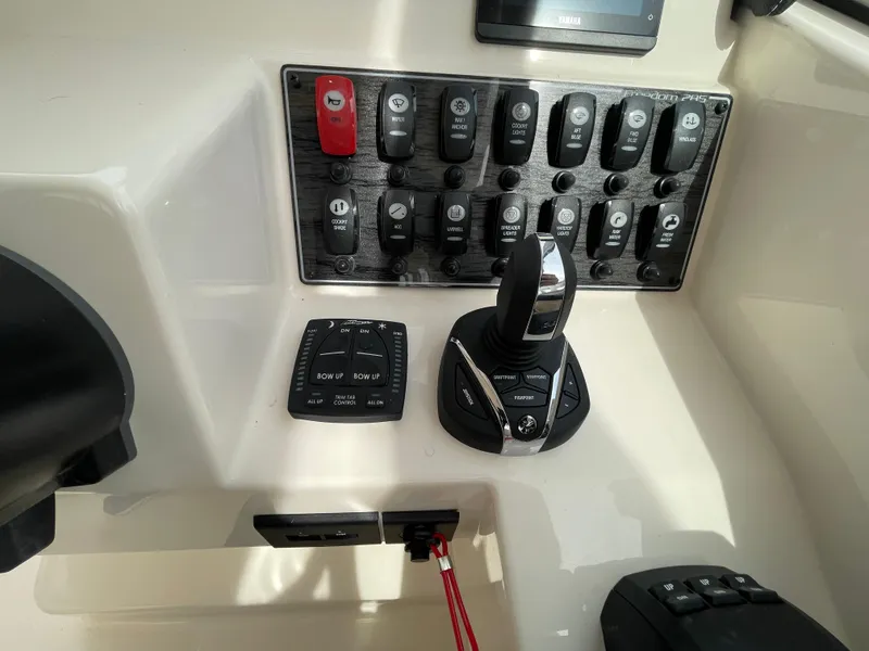 Slide: The Image of Control panel of 2025 Grady-White Freedom 285 boat with switches and throttle. - 17