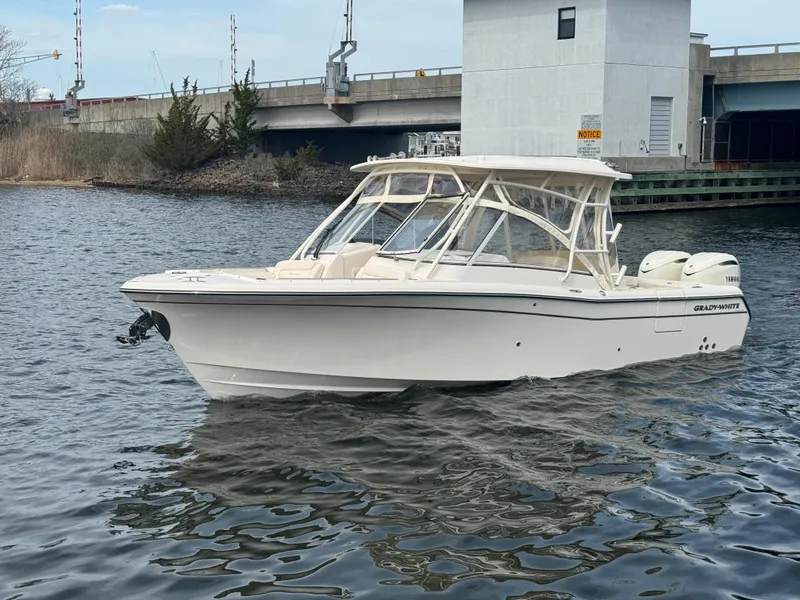 Slide: The Image of 2025 Grady-White Freedom 285 boat on calm water near a bridge. - 2