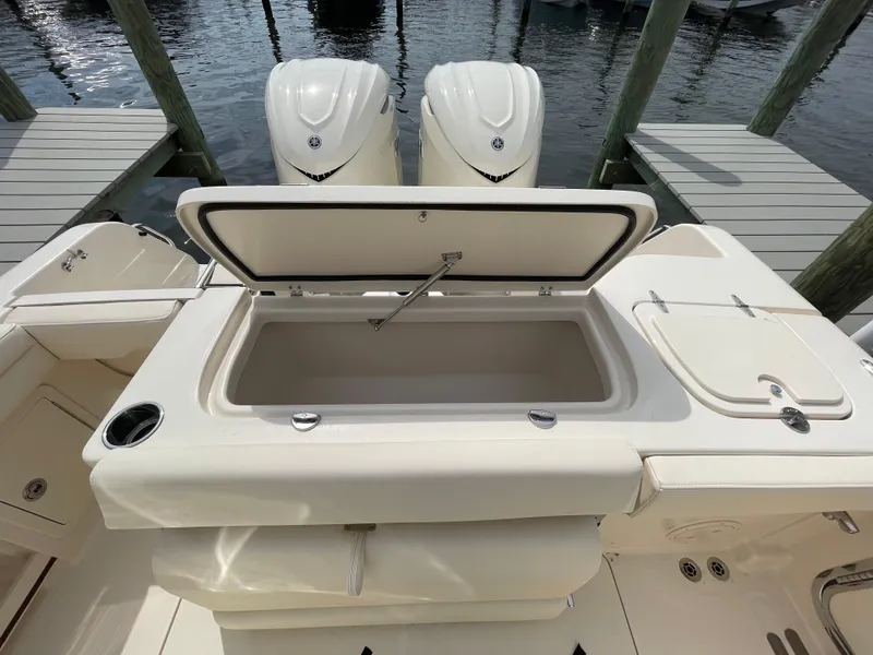 Slide: The Image of 2025 Grady-White Freedom 285 boat with open storage compartment, docked by the water. - 25