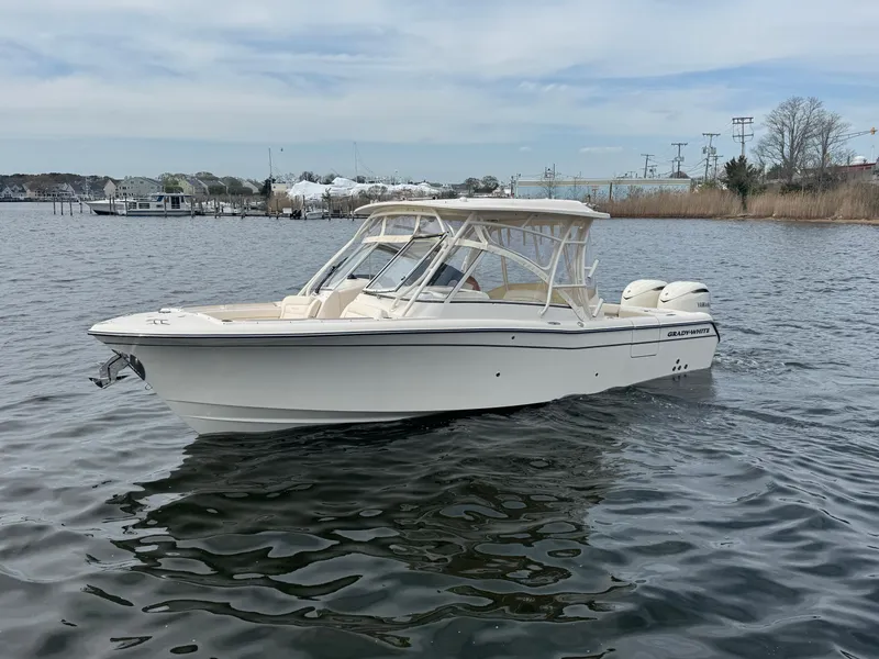 Slide: The Image of 2025 Grady-White Freedom 285 boat on calm water, showcasing sleek design and dual engines. - 4