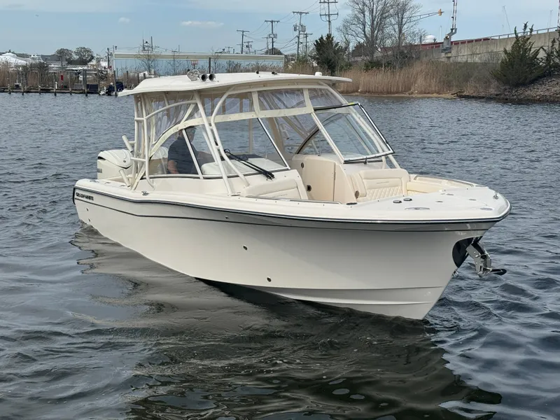 Slide: The Image of 2025 Grady-White Freedom 285 boat on calm water, showcasing sleek design and spacious deck. - 6