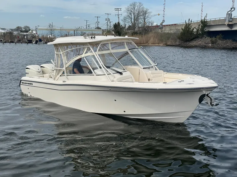 Slide: The Image of 2025 Grady-White Freedom 285 boat cruising on a calm river near a bridge. - 7