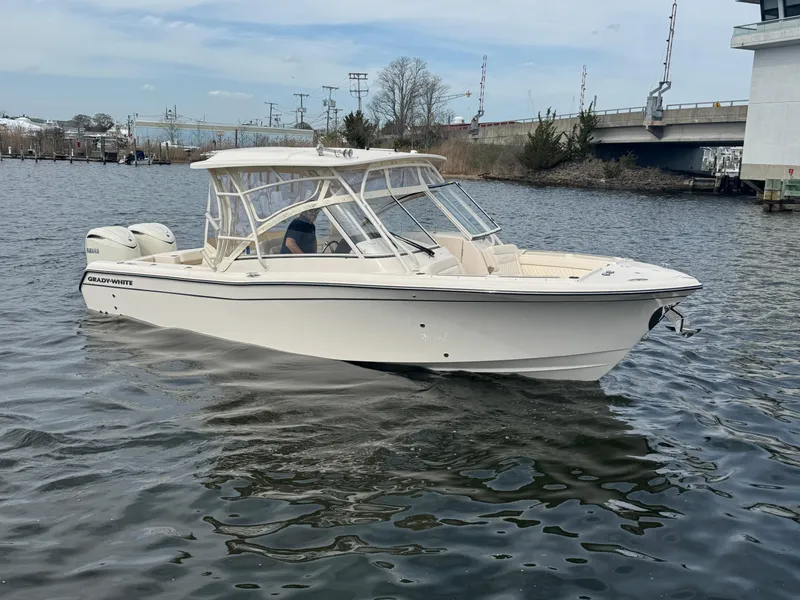 Slide: The Image of 2025 Grady-White Freedom 285 boat on calm water near a bridge. - 9