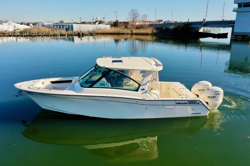 Slide: The Image of 2025 Grady-White Freedom 345 boat on calm water, showcasing sleek design and twin engines. - 11
