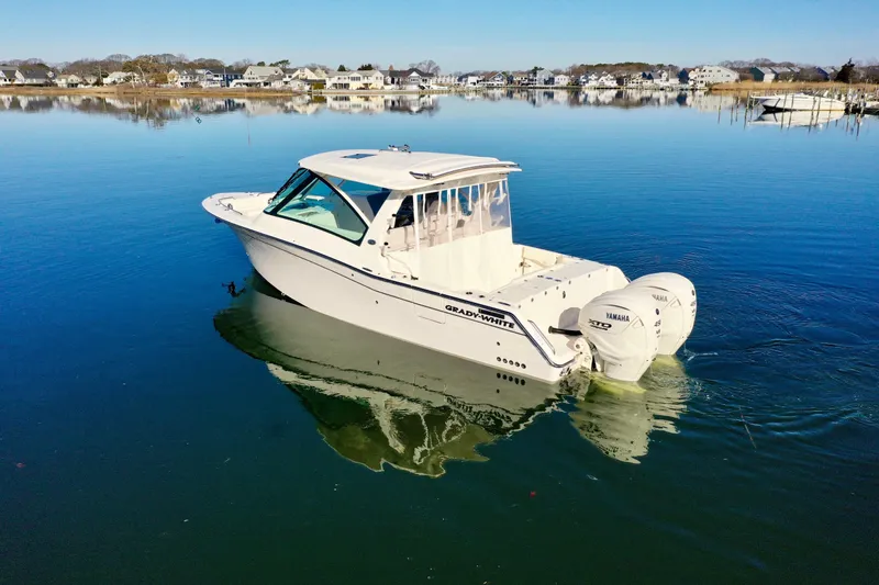 Slide: The Image of 2025 Grady-White Freedom 345 boat on calm water, showcasing sleek design and twin engines. - 14
