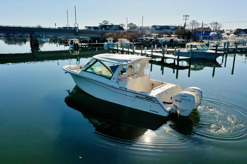Slide: The Image of 2025 Grady-White Freedom 345 boat docked in a serene marina setting. - 16