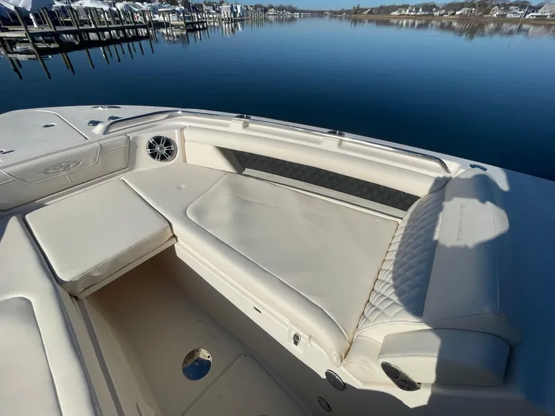 Slide: The Image of 2025 Grady-White Freedom 345 boat interior with cushioned seating by calm waters. - 20