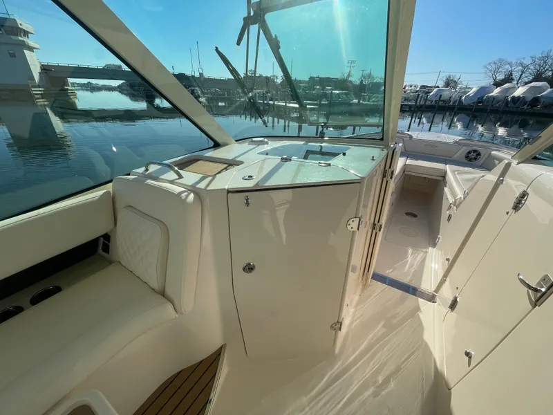 Slide: The Image of 2025 Grady-White Freedom 345 boat interior with seating and helm, docked by the water. - 21