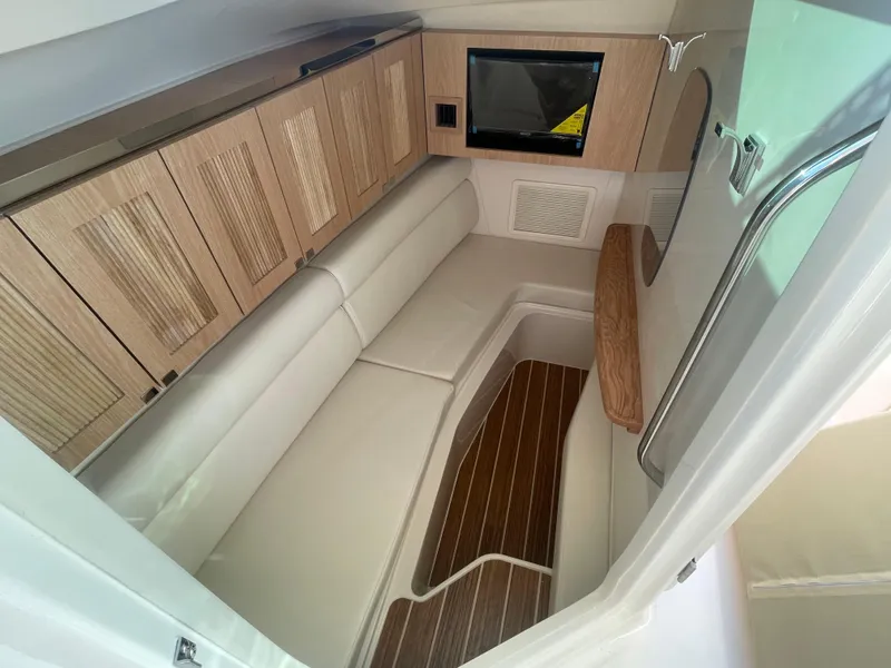 Slide: The Image of 2025 Grady-White Freedom 345 cabin interior with wood accents and comfortable seating. - 23