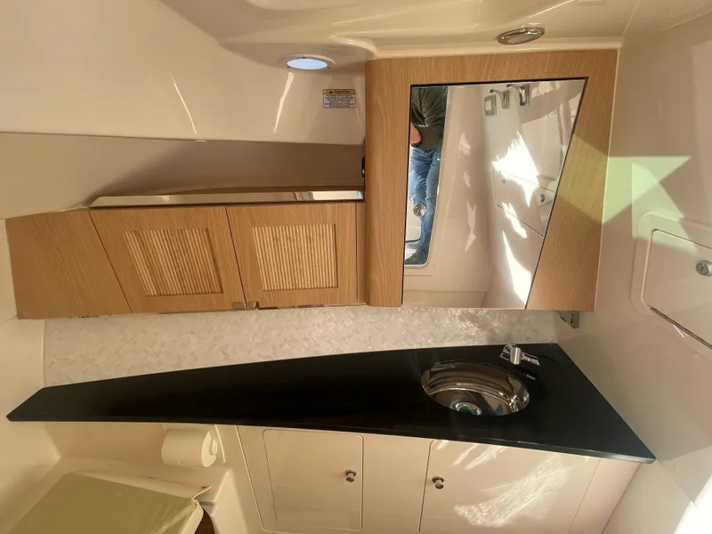 Slide: The Image of Interior of 2025 Grady-White Freedom 345 boat, featuring modern bathroom with sink and mirror. - 28