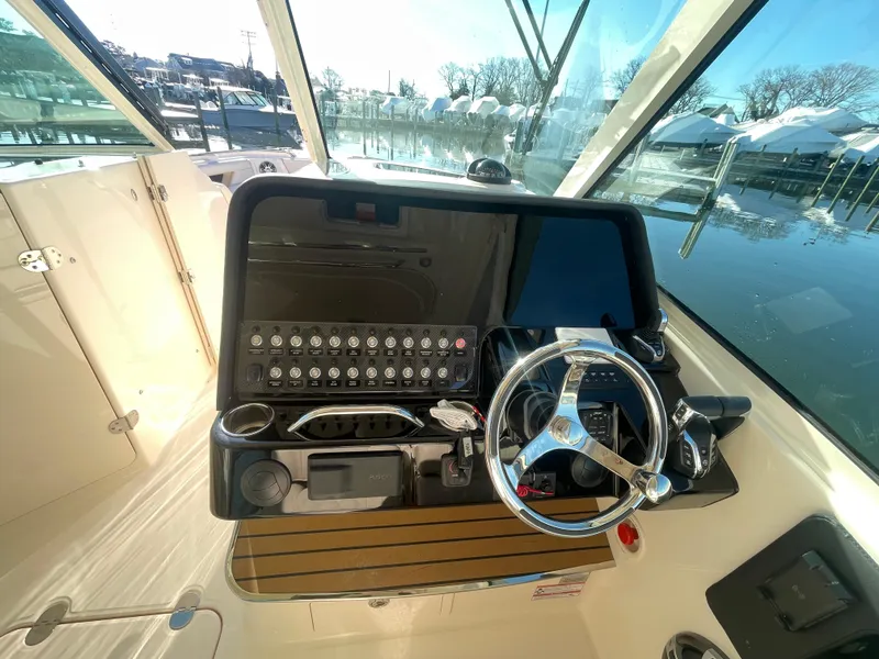 Slide: The Image of 2025 Grady-White Freedom 345 helm with modern controls and steering wheel. - 32