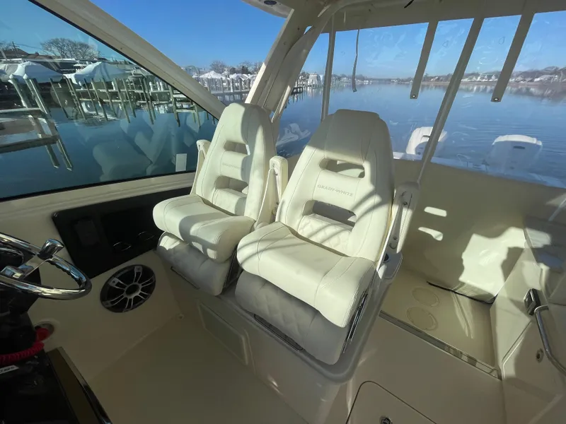 Slide: The Image of 2025 Grady-White Freedom 345 boat interior with plush seating and scenic water view. - 33