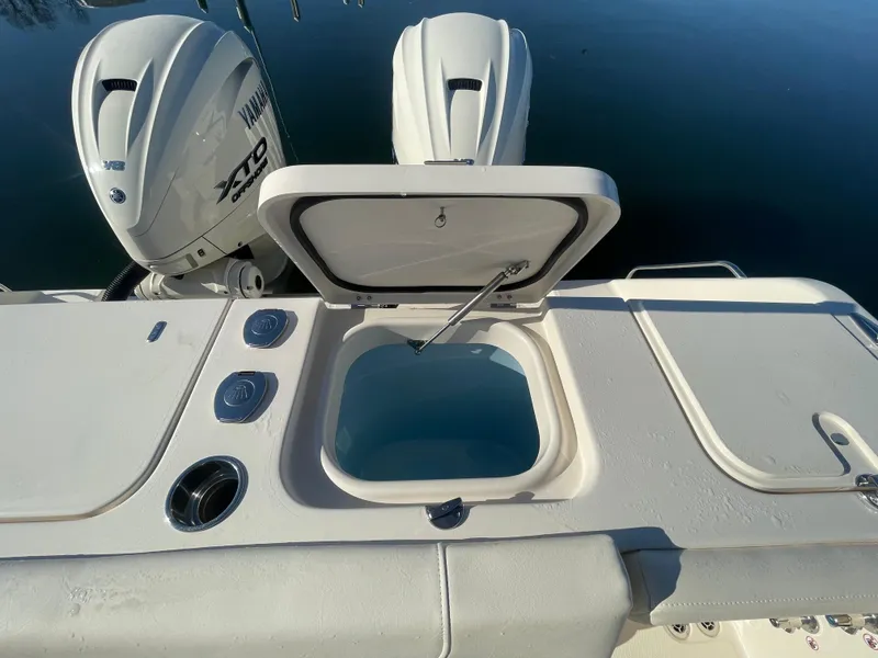 Slide: The Image of 2025 Grady-White Freedom 345 boat with open storage compartment and dual Yamaha engines. - 45
