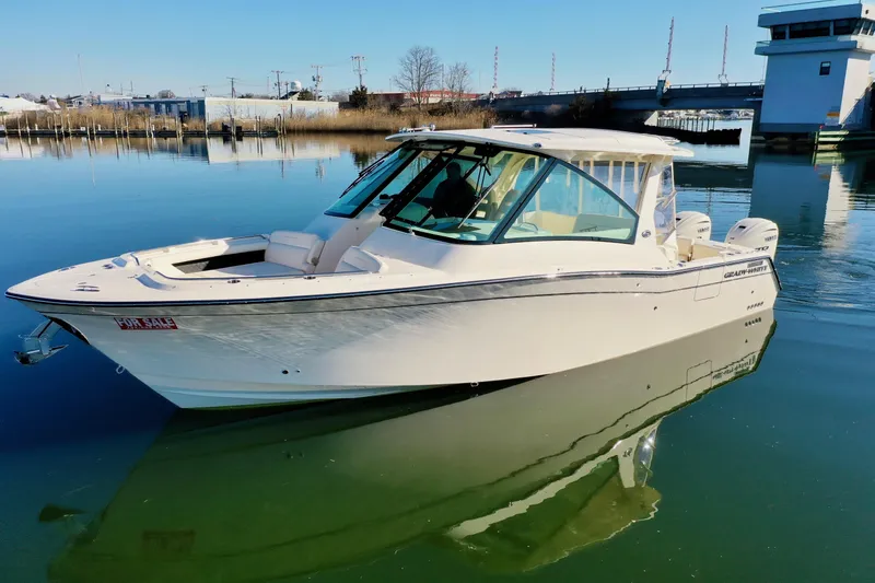 Slide: The Image of 2025 Grady-White Freedom 345 boat on calm water near a marina. - 6