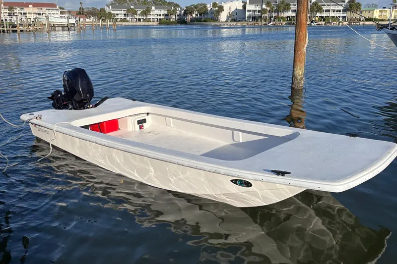 Slide: The Image of 2025 Rabco Buccaneer boat on calm water, featuring a sleek white design. - 1